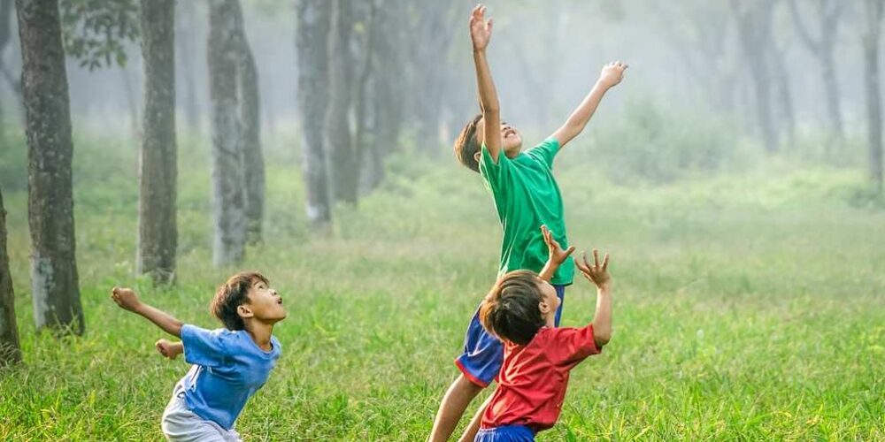 Dei bambini giocano all’aperto in un parco: l’educazione ambientale va insegnata fin dalla scuola primaria