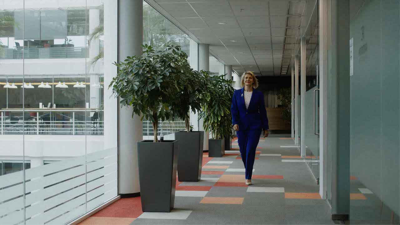 Una donna cammina in un corridoio di un’azienda: il risparmio energetico deve interessare anche gli uffici e i negozi