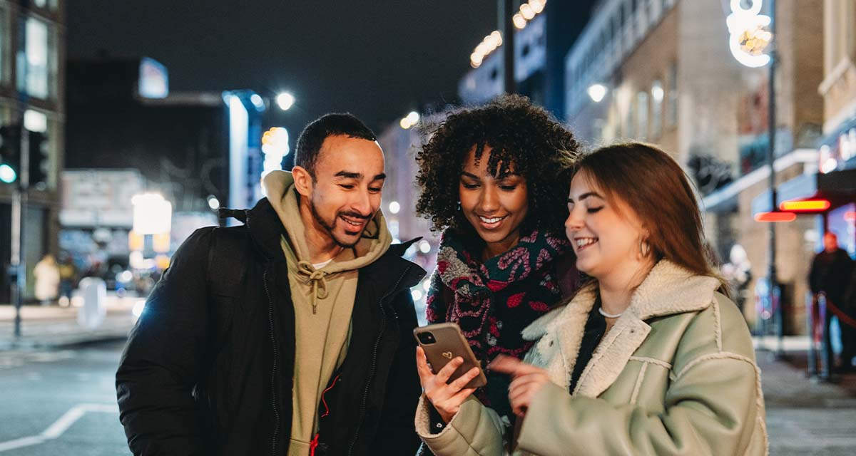 Due ragazze e un ragazzo utilizzano l’App E.ON su uno smartphone