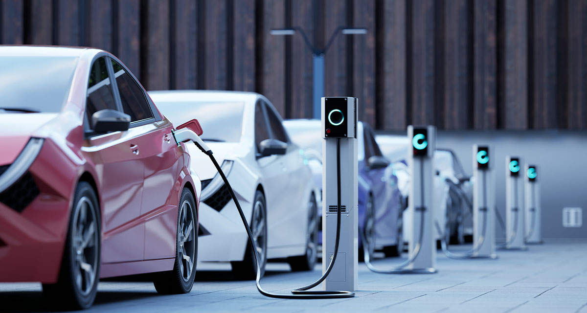 Fila di auto elettriche in ricarica presso colonnine pubbliche