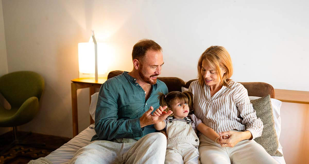 Una famiglia si rilassa in camera da letto, la zona ideale per utilizzare una luce calda