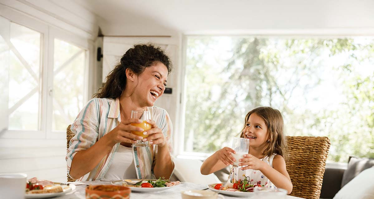 Una giovane mamma gioca con la figlia in un soggiorno: le pompe di calore offrono la migliore climatizzazione per gli ambienti domestici