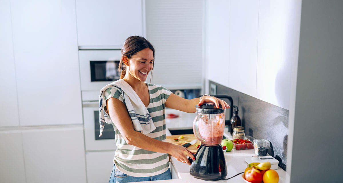 Una ragazza utilizza un frullatore in cucina: elettrodomestici con alta classe energetica aiutano a ridurre i consumi elettrici