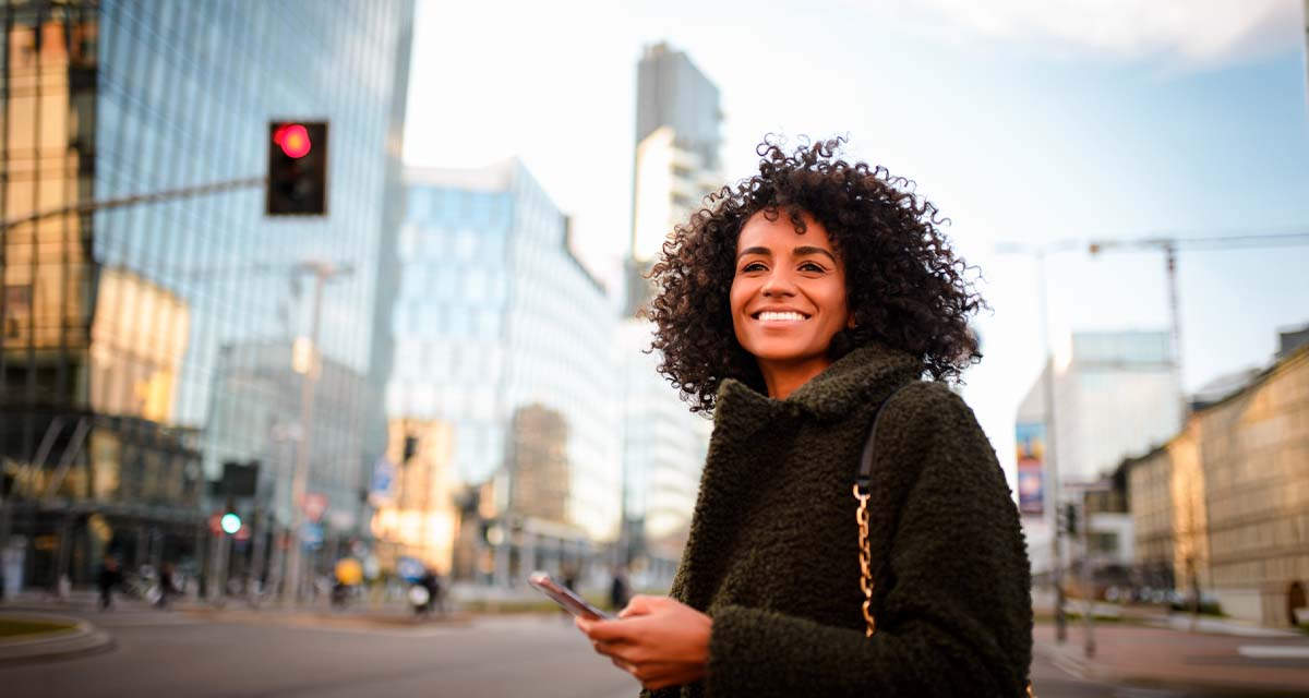 Una ragazza sorridente sulle strade di Milano: esistono molte offerte luce e gas per la capitale lombarda