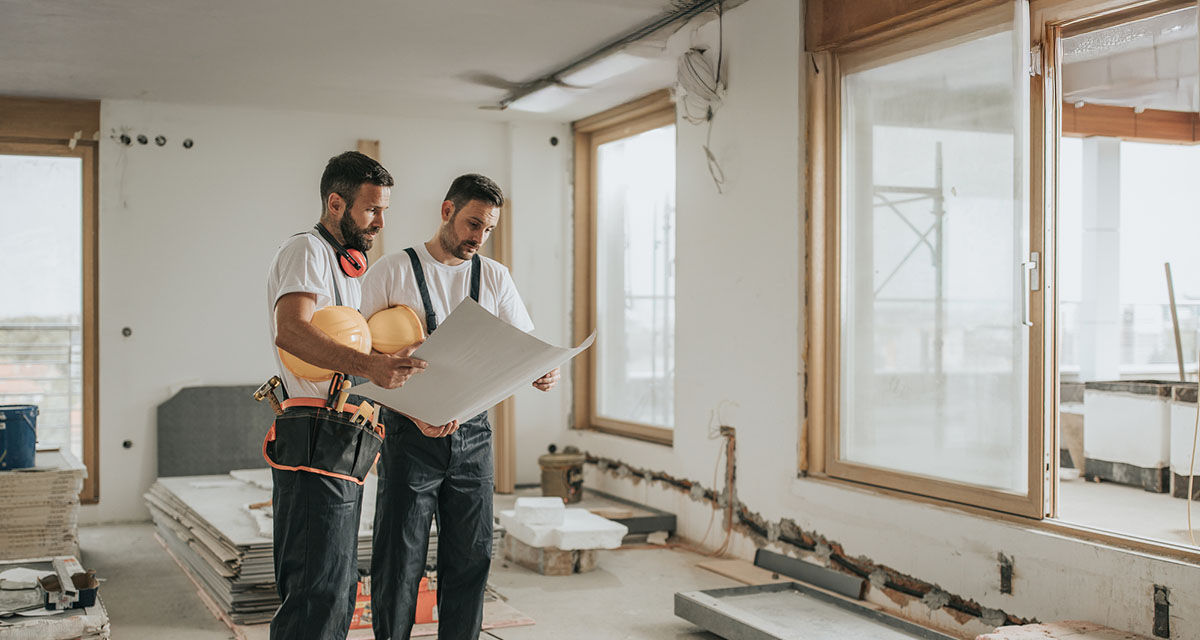 Due tecnici studiano le carte per una riqualificazione energetica di un condominio